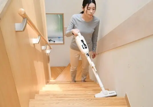 通販生活のマキタターボ60で階段を掃除する女性